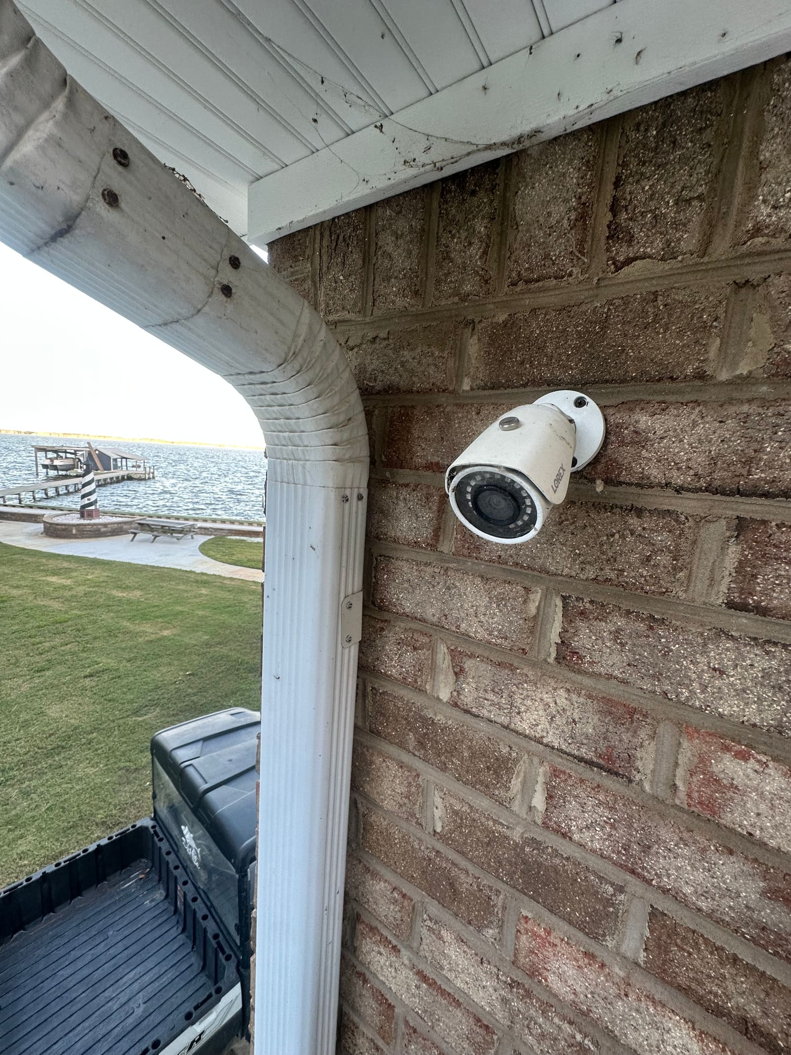 Bullet camera mounted on brick with the waterfront behind