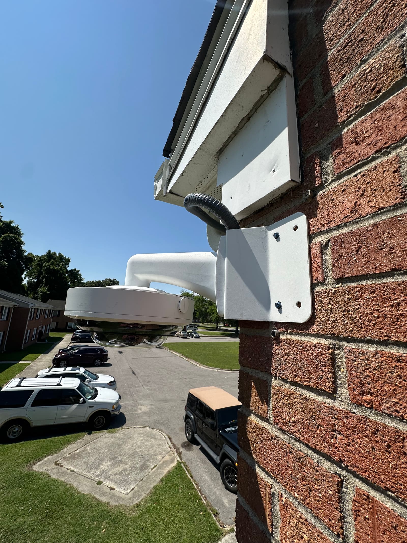 Dome security camera installed on a brick apartment building