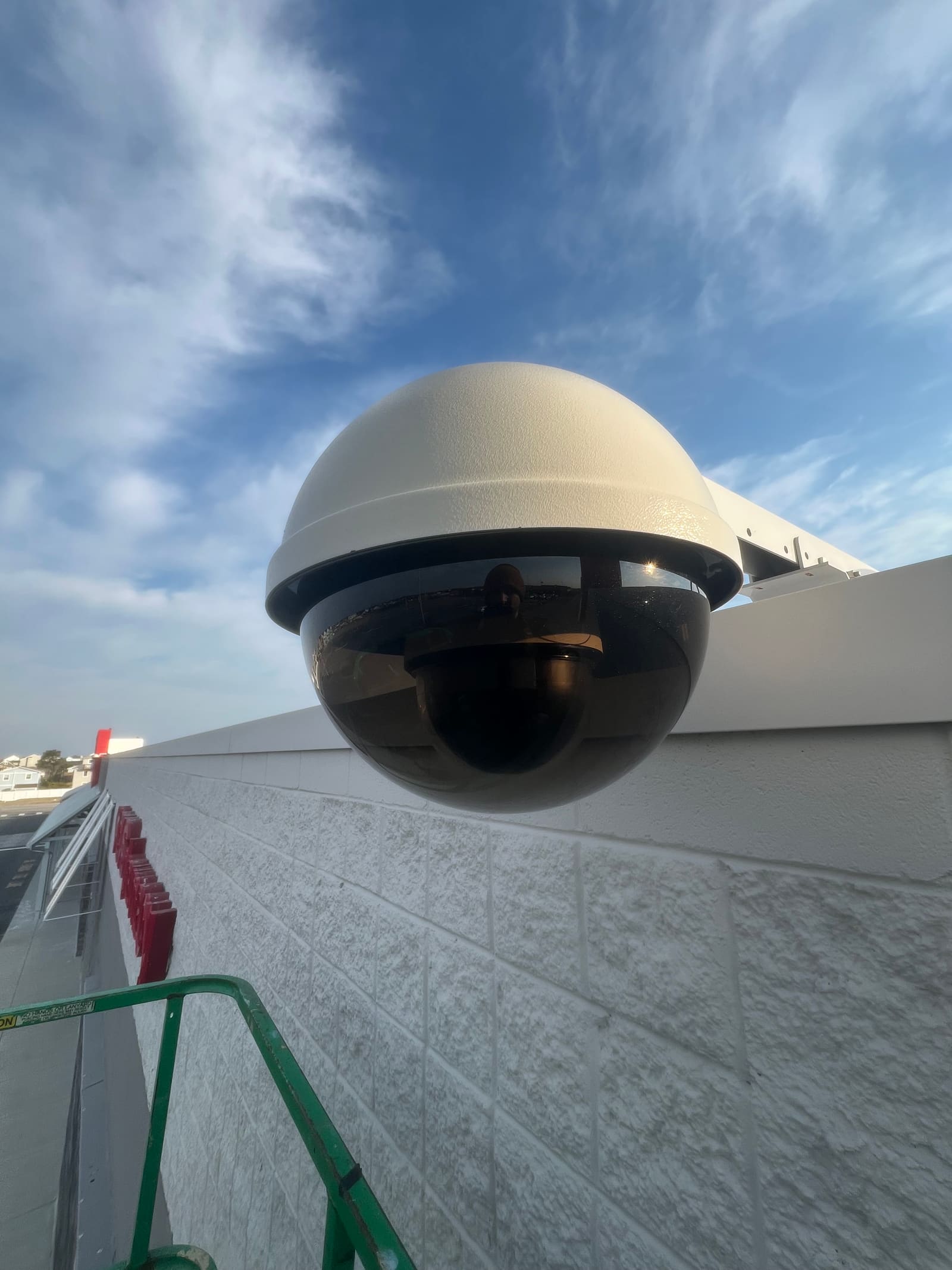 Weatherproof dome camera installed against a coastal sky