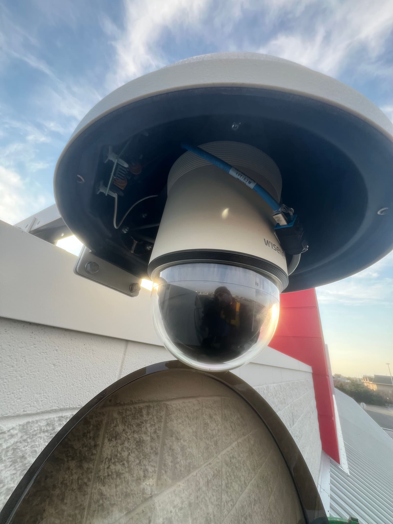 Close-up of a PTZ dome security camera against the sky