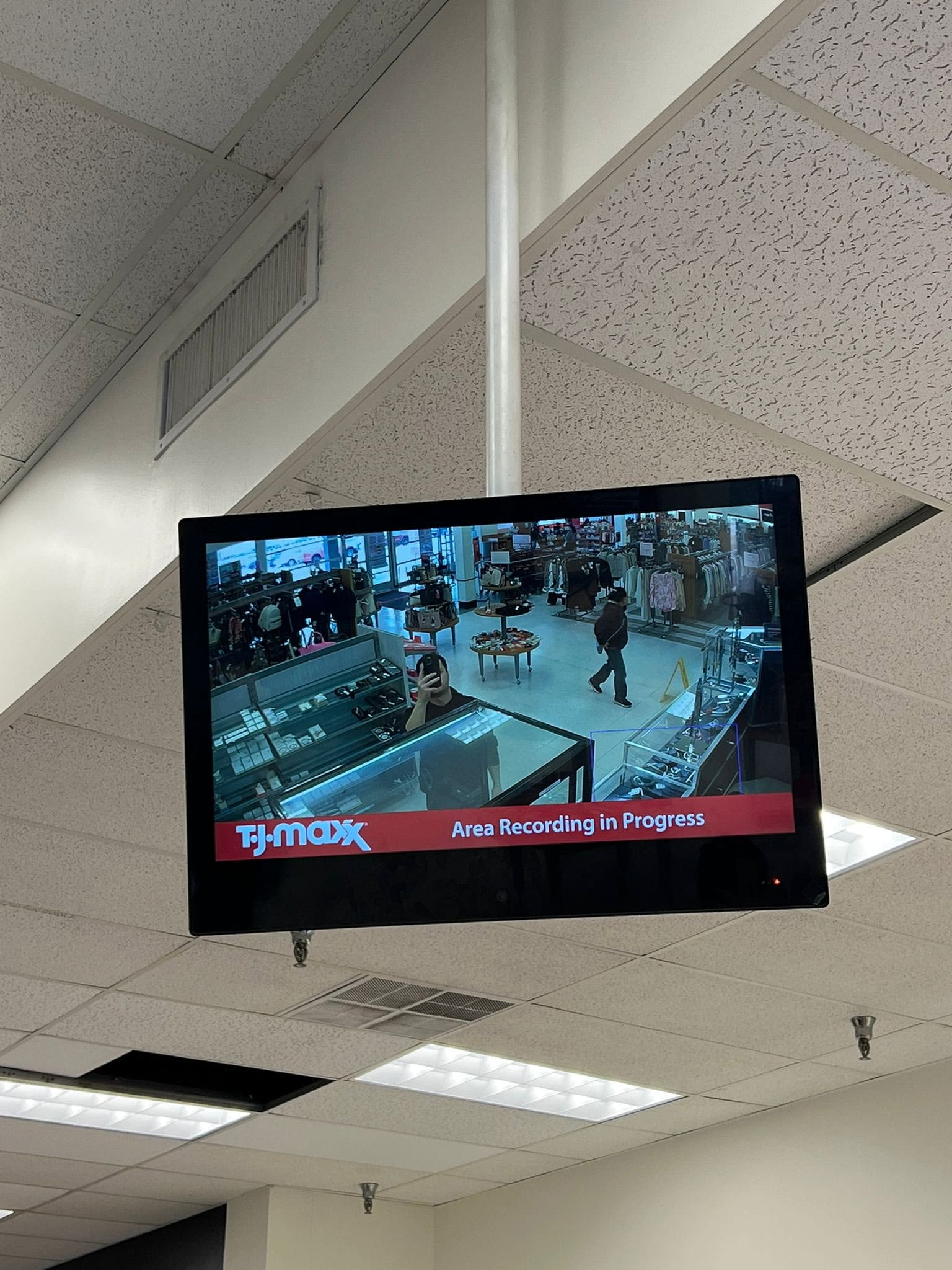 Public-view monitor showing a live camera feed at a retail entrance