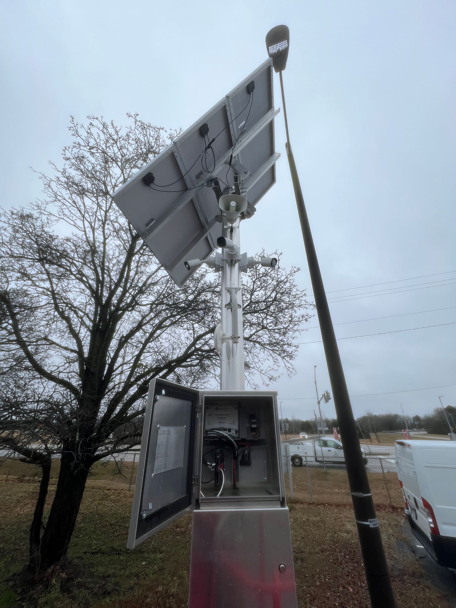 Solar-powered camera mounted on a pole with battery enclosure